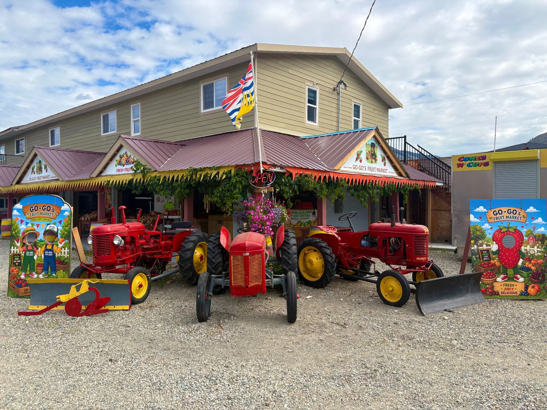 Go-Go's Fruit Market storefront with vintage red tractors in Cawston, BC